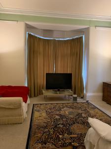 a living room with a flat screen tv and a couch at The Old Vicarage in South Norwood