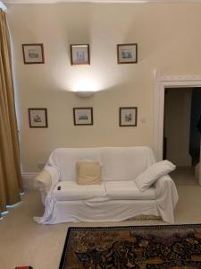 a white couch sitting in a living room at The Old Vicarage in South Norwood