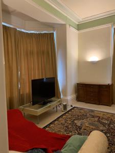 a living room with a television and a couch at The Old Vicarage in South Norwood