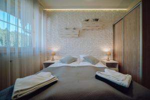 a bedroom with a large bed with towels on it at Dolina Wikingów 2-poziomowy apartament w Norweskiej Dolinie z dwoma balkonami i dostępem do strefy Wellness in Szklarska Poręba