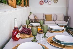 a table with plates and glasses and a bottle of wine at 2BR Private Pool House Near Lisbon & Beaches in Parede