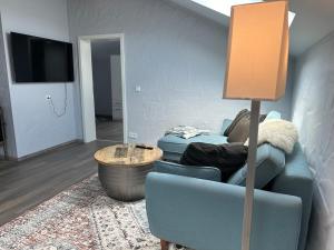 a living room with a blue couch and a flat screen tv at Wolke 7 in Dahlem