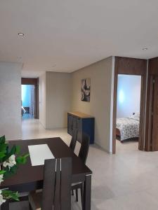 a dining room with a table and chairs and a bed at Superbe appartement A33 in Kenitra