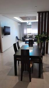 a living room with a table and chairs and a couch at Superbe appartement A33 in Kenitra