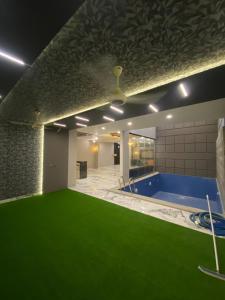 ein großer Raum mit Pool und grünem Boden in der Unterkunft 5 bed room luxury villa in DHA phase 8 in Lahore