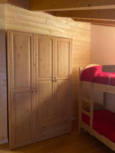1 dormitorio con armarios de madera y litera en Residenza Colere Ski 2024, en Colere