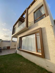 ein Gebäude mit großen Fenstern und einer Liegewiese in der Unterkunft 5 bed room luxury villa in DHA phase 8 in Lahore