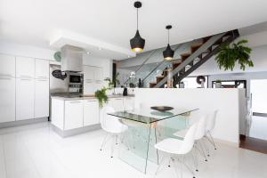 a kitchen with a glass table and white chairs at Villa Cleo, vistas de ensueño in San Miguel de Abona