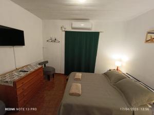 ein Schlafzimmer mit einem Bett und einem grünen Vorhang in der Unterkunft Departamento Céntrico con Estacionamiento in Oberá + 4 Fotos