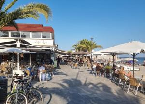 サン・ペドロ・デル・ピナタルにあるCasa Flamingo - Corner house near beach & boulevard with sea & salt lake viewの海岸のテーブルと椅子に座る人々