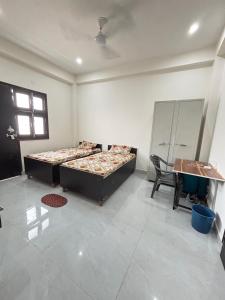 Habitación con 2 camas y escritorio. en next gen pg and rooms, en Noida