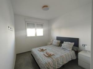 ein Schlafzimmer mit einem Bett mit zwei Handtüchern darauf in der Unterkunft Velez Malaga 2 Dorm 4 Huésped Piscina Parking WiFi in Vélez-Málaga + 20 Fotos
