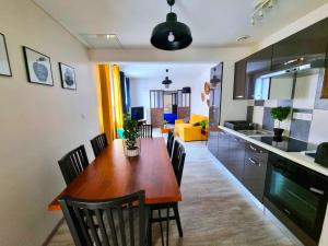 une cuisine et une salle à manger avec une table et des chaises en bois dans l'établissement Loft décoration Seventies, à Elbeuf
