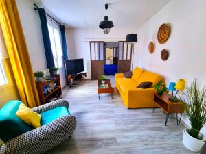 d'un salon avec un canapé et des fauteuils jaunes. dans l'établissement Loft décoration Seventies, à Elbeuf