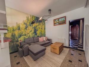 a living room with a couch and a painting on the wall at La Grande Maison Saint Hilaire in Nogent-le-Rotrou