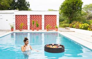 a woman in a swimming pool with a wheel in the water at The Castle Villa - Luxury Villa Resort with Private Swimming Pool in Udaipur