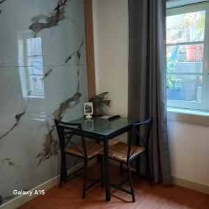 una mesa y una silla en una habitación con ventana en Villa Regio Studio & Garden, en Vila do Conde