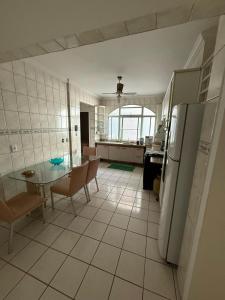 una cucina con tavolo e frigorifero di Apartamento em prédio na Praia do Morro a Guarapari