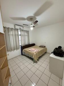 una camera da letto con un letto e un ventilatore a soffitto di Apartamento em prédio na Praia do Morro a Guarapari