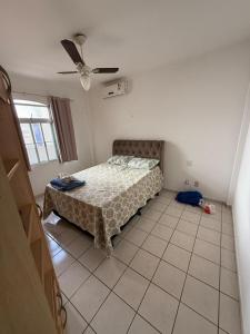 una camera da letto con un letto e un ventilatore a soffitto di Apartamento em prédio na Praia do Morro a Guarapari Altre 5 foto