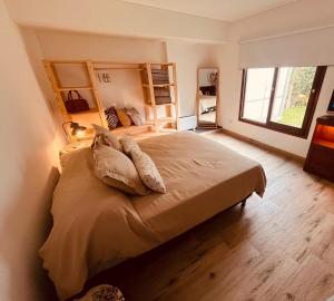 a bedroom with a bed with pillows and a window at Casa Waikiki in Mar del Plata