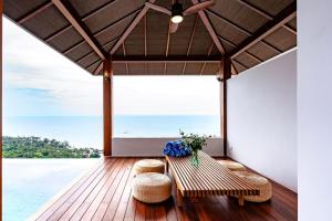 a porch with two benches and a view of the ocean at Anzhu Seamate Villa Samui in Lamai +226 photos