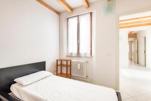 a white bedroom with a bed and a window at Large apartment with 2 bedrooms in the historic center in Reggio Emilia +35 photos