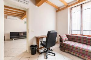 a living room with a chair and a couch at Large apartment with 2 bedrooms in the historic center in Reggio Emilia