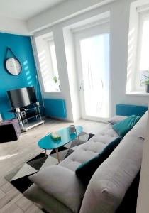 a living room with a couch and a table at Le ptit Cosy appartement privatif in Bining-lès-Rohrbach