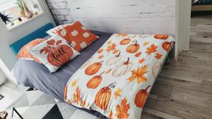 a bed with a pumpkin comforter and pillows at Le ptit Cosy appartement privatif in Bining-lès-Rohrbach
