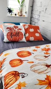 a bed with a comforter with a pumpkin on it at Le ptit Cosy appartement privatif in Bining-lès-Rohrbach