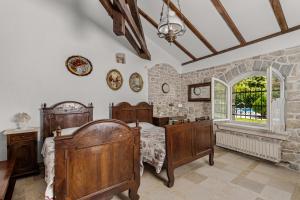 a bedroom with a bed and a stone wall at Villa Stori Grod in Ružići +16 photos
