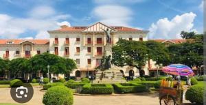 a large building with a statue in front of it at Quarto c banheiro para uma pessoa in Poços de Caldas