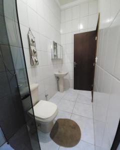 a bathroom with a toilet and a sink at Quarto c banheiro para uma pessoa in Poços de Caldas