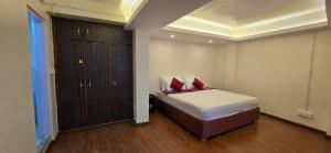 ein Schlafzimmer mit einem Bett mit zwei roten Kissen in der Unterkunft The Hillscape in Darjeeling