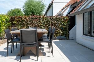 Una mesa y sillas de madera en un patio. en Casa Azul, en Nieuwpoort