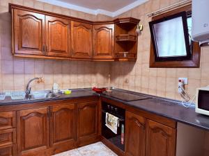 een keuken met houten kasten en een spoelbak bij Lovely Los Cris Apartment in Los Cristianos