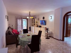 een woonkamer met een tafel en een bank bij Lovely Los Cris Apartment in Los Cristianos