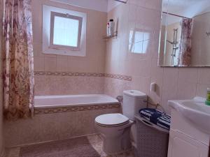 een badkamer met toilet, bad en wastafel bij Lovely Los Cris Apartment in Los Cristianos