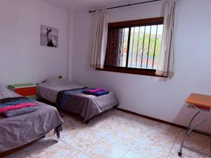 een kamer met twee bedden en een raam bij Lovely Los Cris Apartment in Los Cristianos