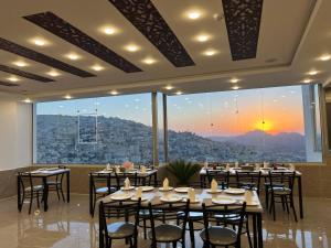 a dining room with tables and chairs and a large window at The charming view in Wadi Musa