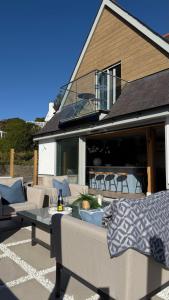 eine Terrasse mit einem Sofa und einem Tisch vor einem Haus in der Unterkunft Bramble Cottage in Criccieth