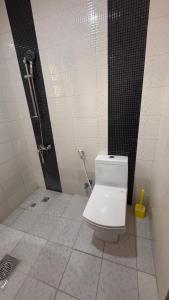 a bathroom with a white toilet and a shower at Grand Safaath in Kuwait