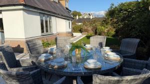 ein Glastisch mit Stühlen und einem Tischasteryasteryasteryasteryasteryasteryasteryasteryaster in der Unterkunft Bramble Cottage in Criccieth