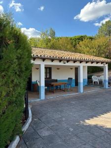 einen Pavillon mit einem Tisch und Stühlen auf einer Terrasse in der Unterkunft Centro Astro Turismo San Benito in Cazalla de la Sierra