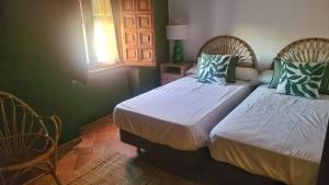 a bedroom with two beds and a window at Cortijo Negretti in Herrera de Alcántara +9 photos