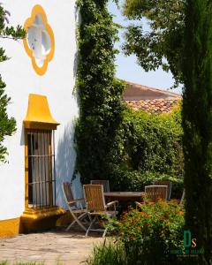 a patio with chairs and a table and a lantern at Cortijo Negretti in Herrera de Alcántara
