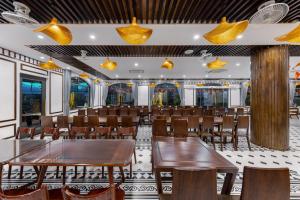 a restaurant with wooden tables and chairs and lights at Tam Coc Orchid Hotel & Spa in Ninh Binh