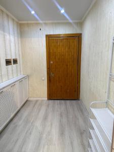 ビシュケクにあるSun City Hostelの木製のドアとウッドフロアの客室です。
