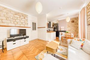 a living room with a couch and a tv at Le Saint Mandé - Aux Portes de Paris & Vincennes in Saint-Mandé